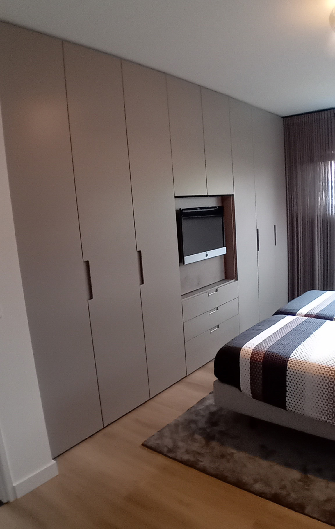 Kastenwand op maat in een woonkamer, met open vakken en gesloten deuren