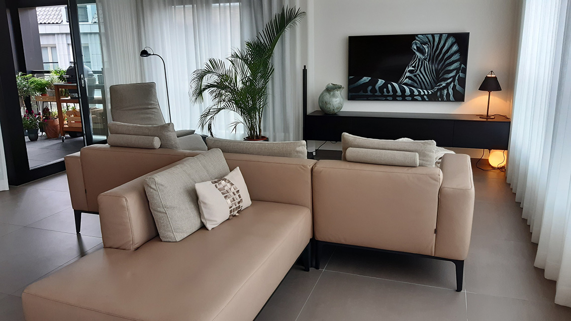 Woonkamer waarin de wand achter de bank de sfeer bepaalt