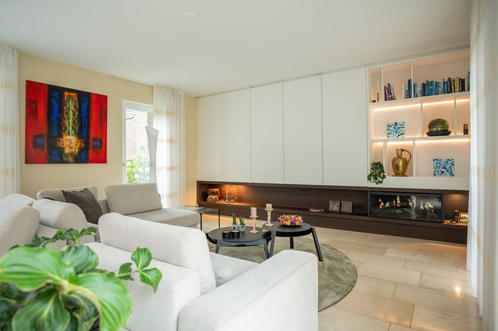 Gestylede woonkamer met kunst aan de wand, accessoires op tafel en een zachte zithoek