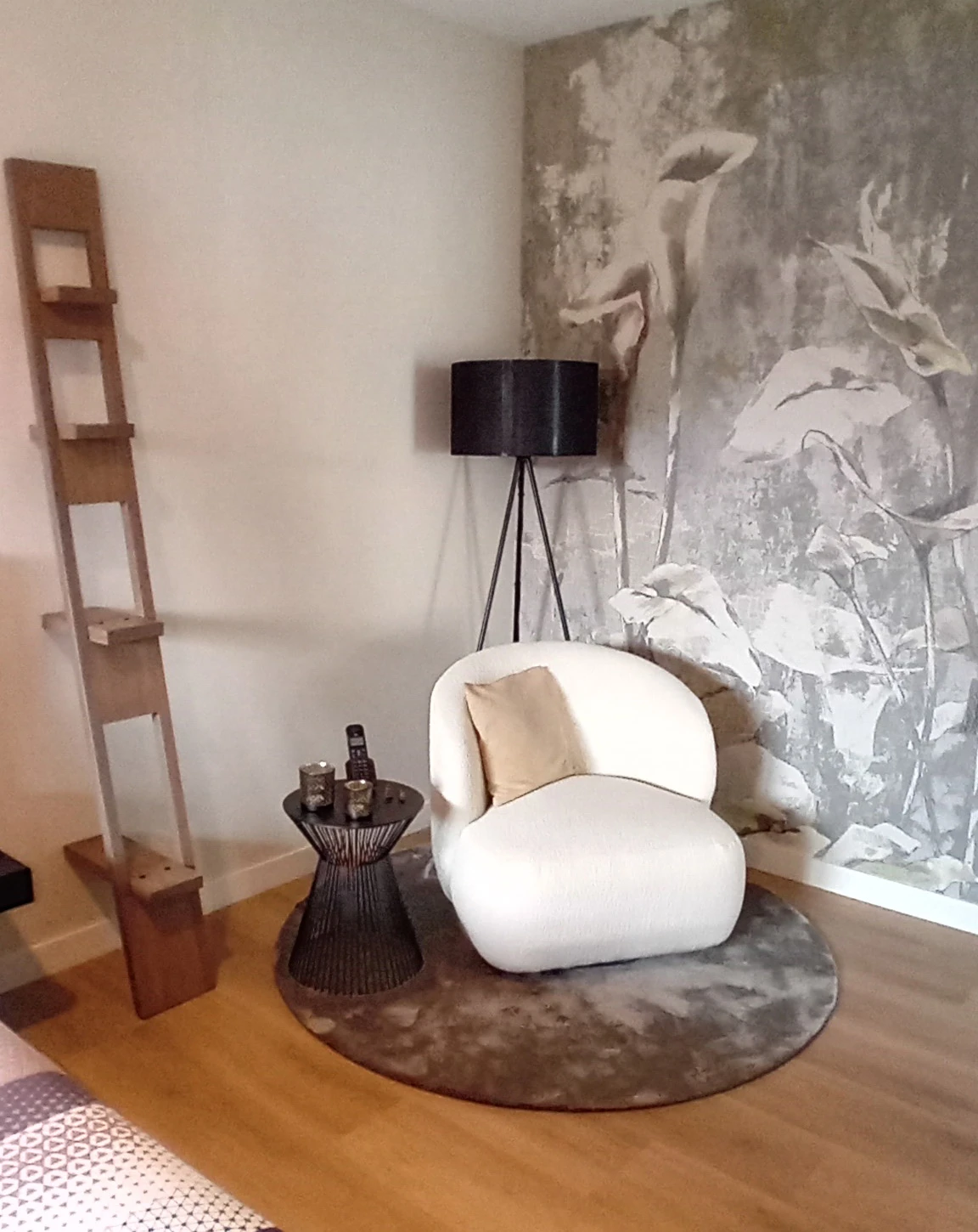 Zithoek met een zachte fauteuil, bijzettafel en een wand met een groot dessin
